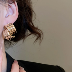 Close-up of gold layered C-shape hoop earrings with a polished metallic finish