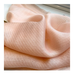 Close-up of pink silk-wool scarf showing delicate pleated texture and soft transparency