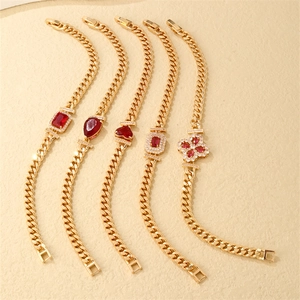 Detail of five gold Cuban link bracelets featuring varied red zircon stones and shapes