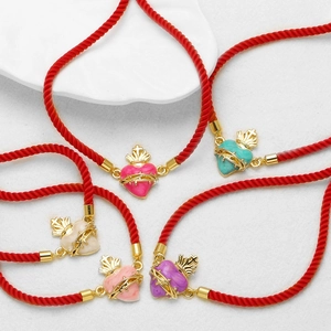 Set di cinque braccialetti in corda rossa con ciondoli a cuore sacro dorati in vari colori