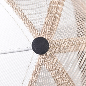 Detail of cotton baseball cap top showing white fabric with beige mesh and black button