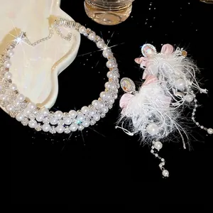 Elegant pearl necklace and pink bow feather earring set on heart shaped tray
