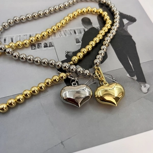 Fashionable gold and silver beaded necklaces with 3D heart pendants set on magazine