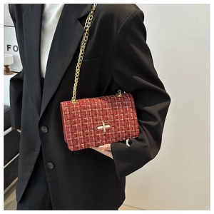 Close-up of red tweed chain bag with gold metallic lock and textured woven fabric