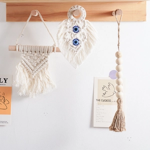 Detail of bohemian woven wall hangings featuring leaf shapes, blue beads and wood accents