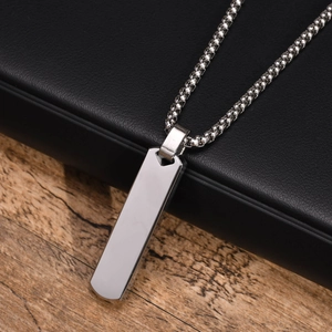 Close-up of a silver stainless steel rectangular pendant on a sleek box chain link