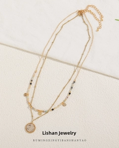 Detail of layered gold choker necklace with marble stone pendant and beads