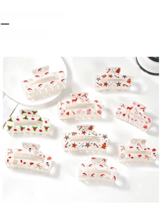 Close-up of translucent cream hair claw clips with various festive Christmas patterns