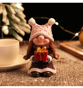 Detailed view of female Christmas gnome figurine with braided hair and red knit hat