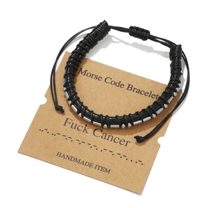 Detail of handmade Morse code leather bracelet on Fuck Cancer message display card