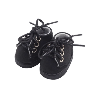 Close-up of black lace-up doll shoes with metal eyelets and detailed rubber soles