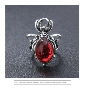 Macro shot of gothic spider ring featuring aged silver metal and large red gemstone
