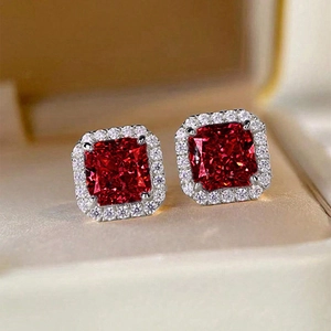 Macro shot of square red gemstone halo earrings set in silver metal jewelry box