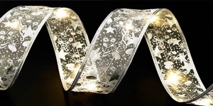 Detail of silver gauze Christmas ribbon with warm LED lights and star patterns