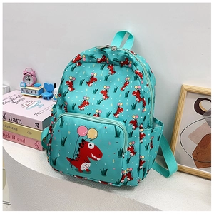 Detail view of mint green toddler backpack with red dinosaur prints on a white table