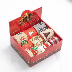 Close-up of assorted Christmas burlap ribbons with reindeer and truck patterns in a red gift box