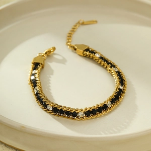 Close-up of gold stainless steel bracelet with black and white zircon stones and lobster clasp