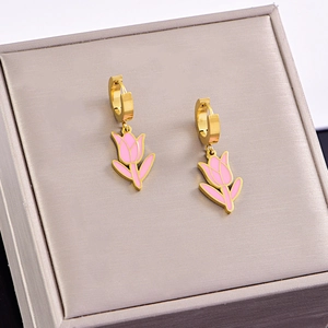 Detail of gold tulip earrings with pink enamel drops on a premium grey jewelry box lid