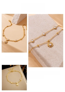 Detail of double-layer gold anklet with pearl flower pendant and adjustable lobster clasp