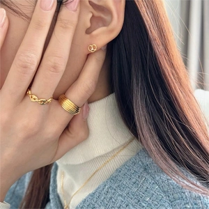 Detailed view of gold pig nose chain ring and layered rings on model finger