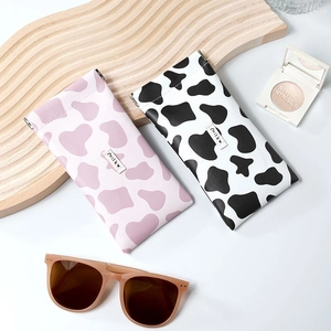 Portable cow print leather sunglasses pouch with metal squeeze closure for eyeglass storage