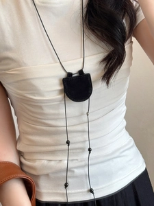 Detail of minimalist black faux leather magnetic glasses holder pendant with beads