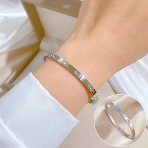 Minimalist silver titanium steel bangle with marquise zircon evil eye motif on wrist