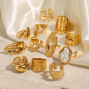 Set of gold stainless steel rings with irregular textures and pearl accents on stone