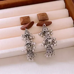 Ethnic bohemian drop earrings featuring square wood pieces and silver beaded bell charms