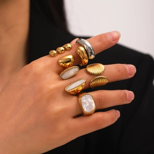 Detailed view of layered stainless steel rings with white shell inlays on hand