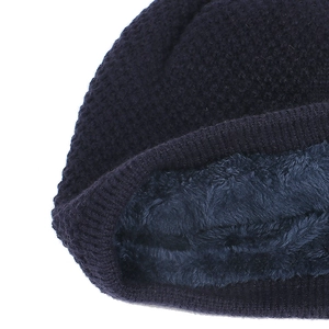 Detailed macro view of the warm navy blue waffle knit and thick fleece lining on the winter hat