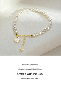 Detailed close-up of pearl bracelet with starfish and shell charms on beige texture