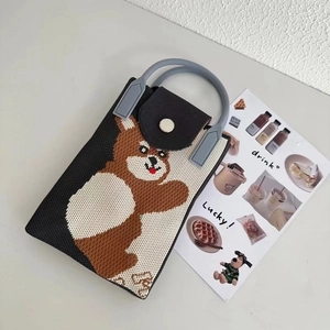 Detail of a mini knitted crossbody bag with a brown bear pattern and contrast colors