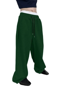 Detail of dark green wide-leg joggers featuring an elastic waistband and black drawstring