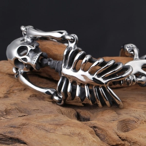 Macro shot of gothic skeleton bracelet made of polished stainless steel on a wood surface