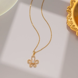 Detail of gold flower necklace with clear crystals and a center pearl inlay