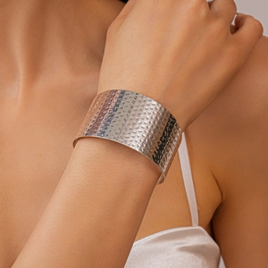 Close-up of a wide hammered silver metal cuff bracelet with irregular wrinkled texture