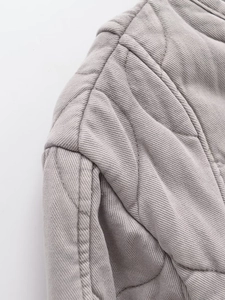 Vista macro dettagliata della giacca di cotone trapuntata tortora con trama del tessuto twill