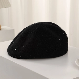 Detail of a black wool beret featuring elegant rhinestone floral and silver sequin accents