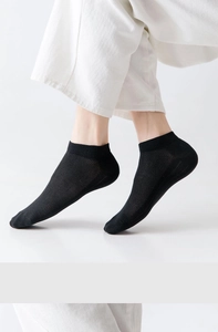 Gros plan de chaussettes basses noires avec texture en maille respirante sur modèle