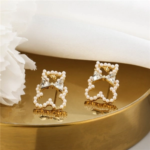 Elegant gold bear stud earrings featuring white pearls and clear cubic zirconia stones