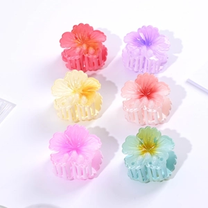 Flat lay macro of six gradient camellia hair claws in assorted pastel jelly colors