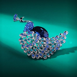 Close-up of crystal peacock brooch with blue gradient rhinestones and silver plating
