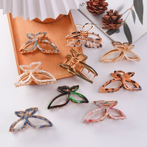 Elegant butterfly alloy hair claws in various acetate colors on a wooden tray