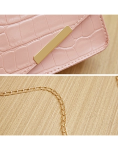 Detailed macro view of pink crocodile-patterned leather and elegant gold chain strap