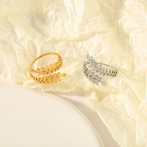 Detailed view of adjustable leaf rings in gold and silver finish on elegant display