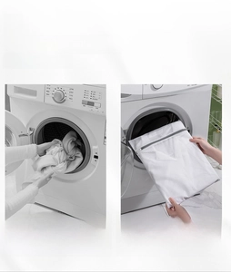 Detail view of white mesh laundry bag with grey zipper showing anti-tangle protection