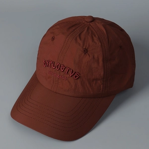 Detail view of burgundy quick-dry baseball cap with embroidered explosive text
