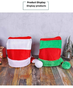 Detail of red-white and red-green striped plush Christmas hats on wooden floor