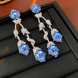 Detail of vintage silver earrings with blue gemstones and rhinestones in luxury display box